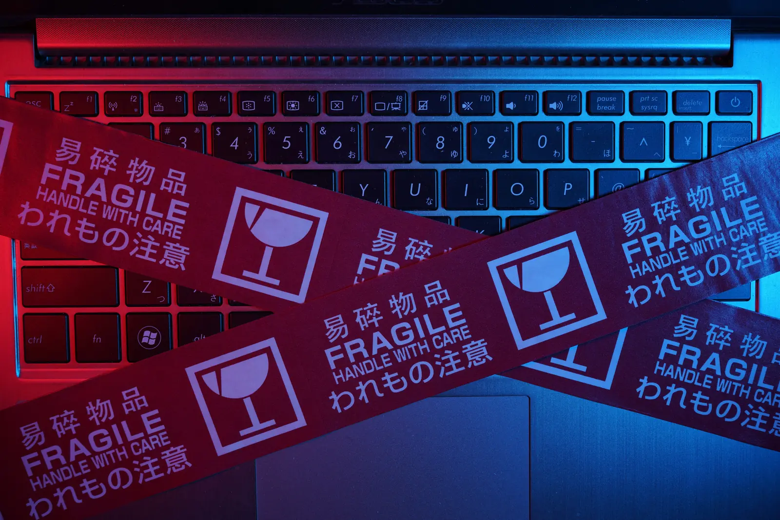 Laptoptoetsenbord afgeplakt met waarschuwingstape als beeld voor een kwetsbare digitale setup